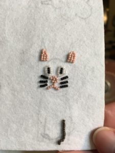The beginnings of a bead-embroidered cat. He's a little frowny, I know.